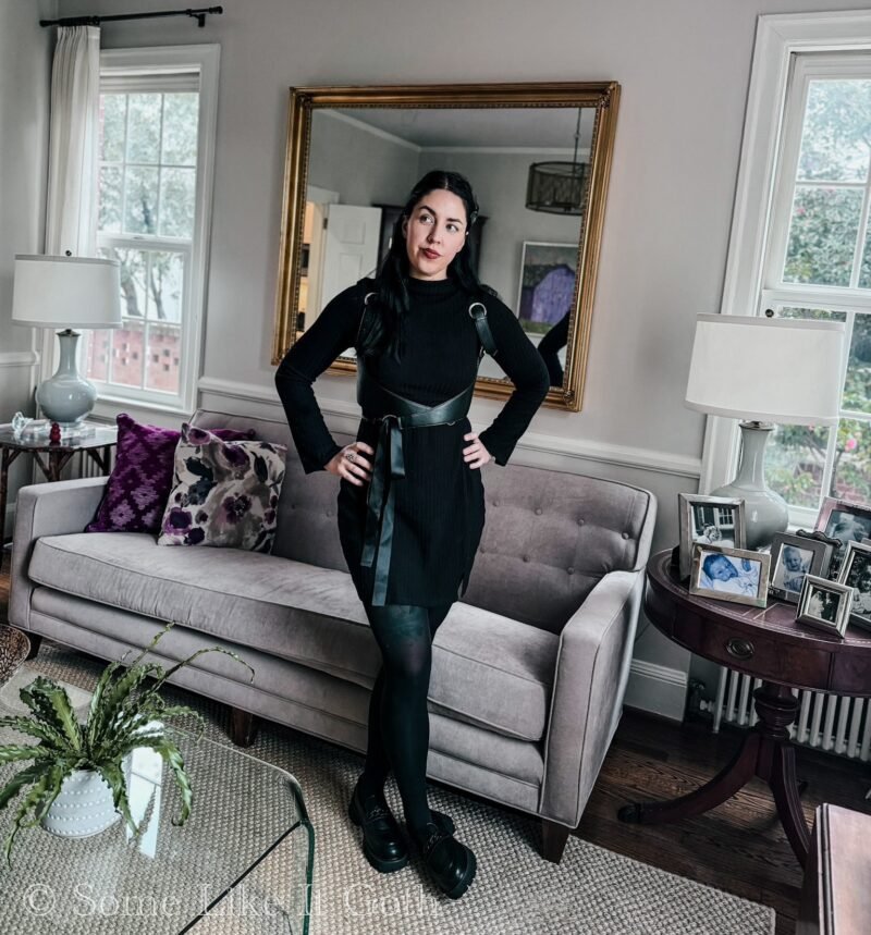 Woman stands with her hands on her hips wearing a romantic goth outfit.