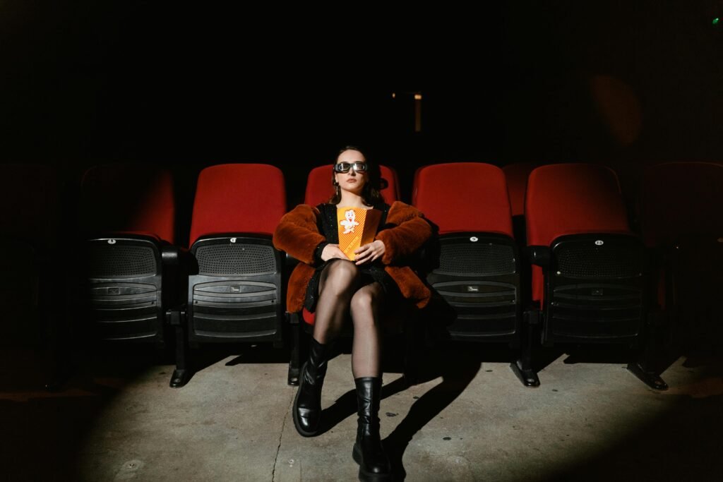 Alternative woman sits in the front row of the theater to watch gothic films.